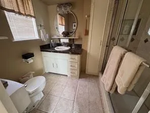 a bathroom with a granite countertop shower and a mirror