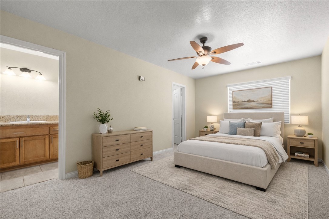 8755 Lilac Road Oak Hills, CA 92344 - Photo 12 of 28 a bedroom with a bed and a chandelier fan
