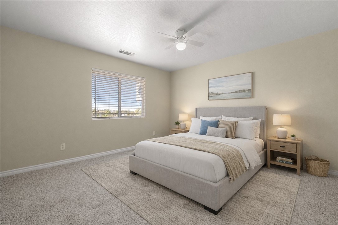 8755 Lilac Road Oak Hills, CA 92344 - Photo 14 of 28 a bedroom with a bed and a window