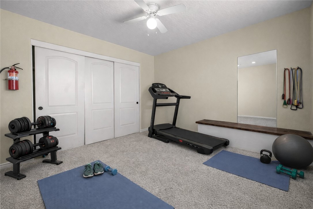 8755 Lilac Road Oak Hills, CA 92344 - Photo 16 of 28 a room with gym equipment and a mirror