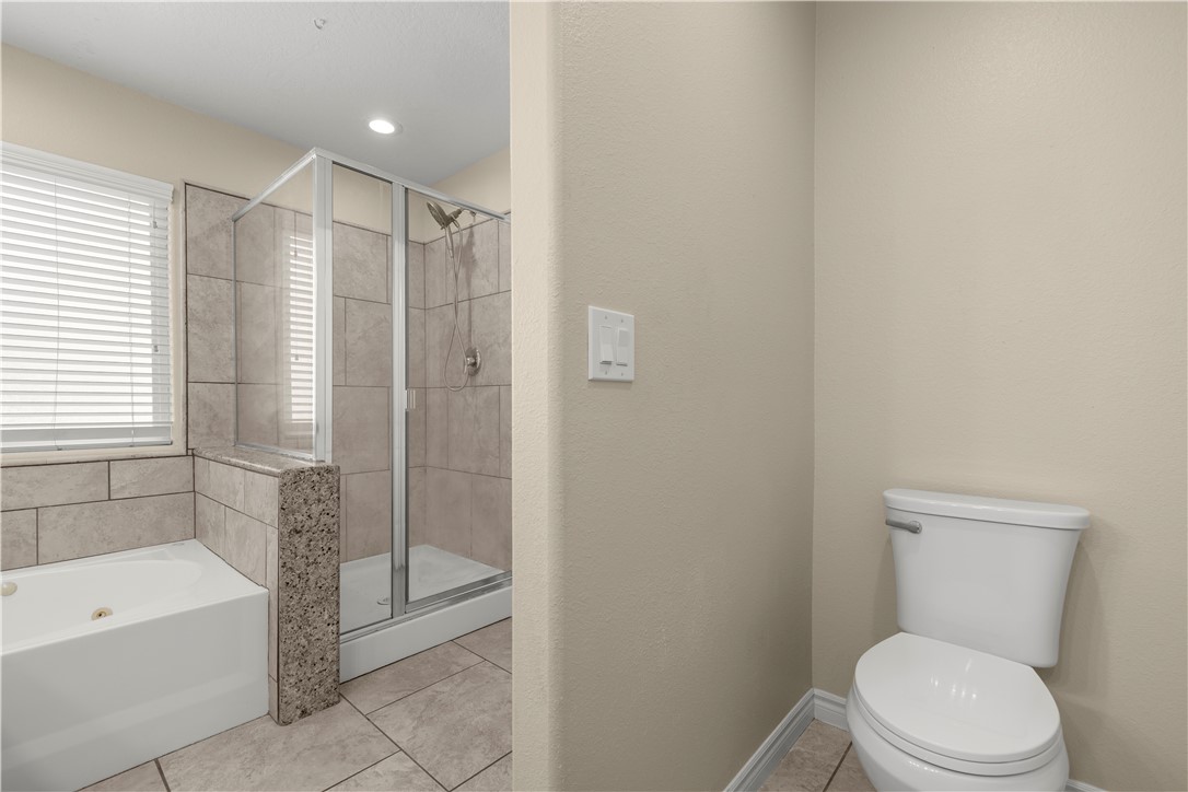 8755 Lilac Road Oak Hills, CA 92344 - Photo 22 of 28 a bathroom with a toilet and a bathtub