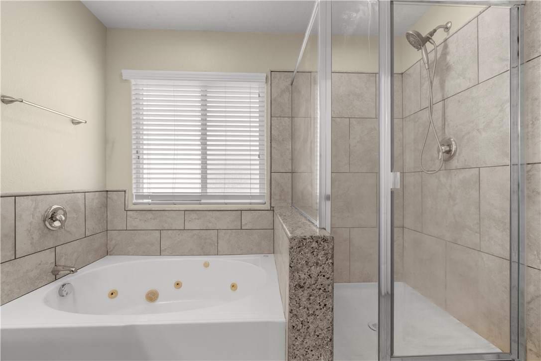 8755 Lilac Road Oak Hills, CA 92344 - Photo 23 of 28 a bathroom with a bathtub and shower