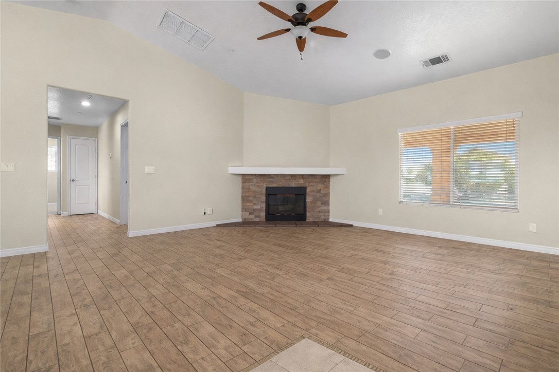 8755 Lilac Road Oak Hills, CA 92344 - Photo 5 of 28 a view of empty room with wooden floor and fireplace