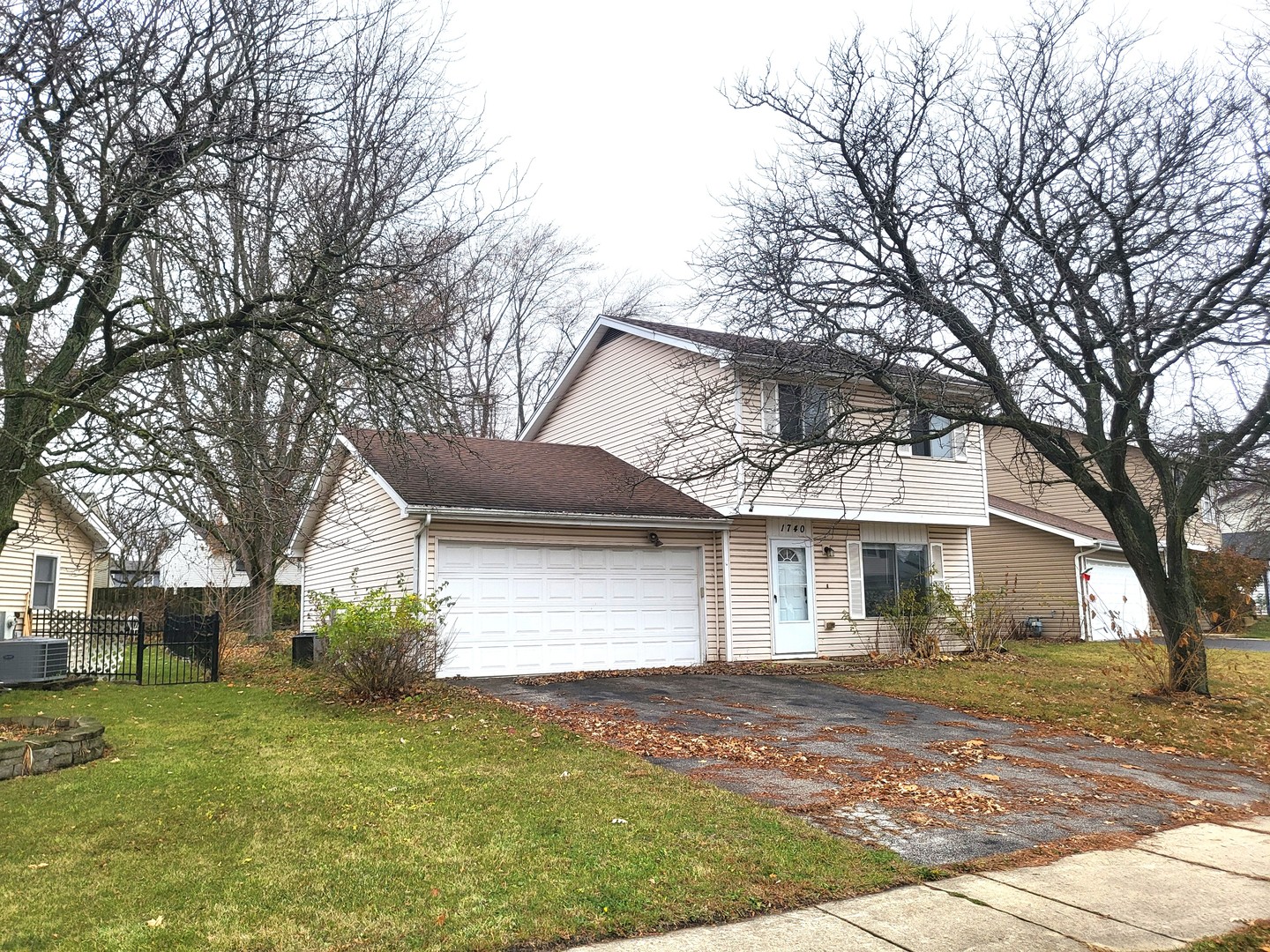 a front view of a house with a garden and trees