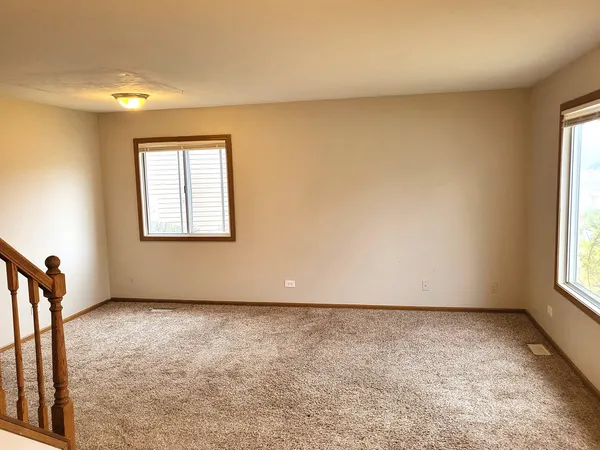 a view of staircase with white walls and a rug