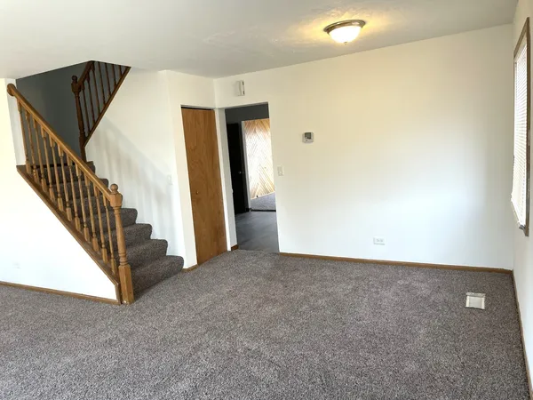 a view of an empty room with a fireplace and a window
