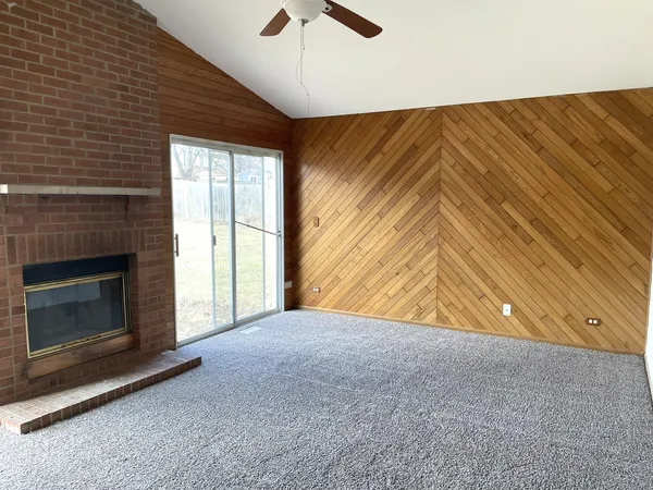 a view of a livingroom with a fireplace and a ceiling fan