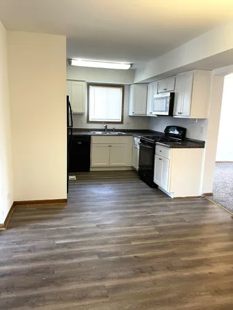 a kitchen with granite countertop a sink cabinets and stainless steel appliances