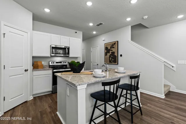 a kitchen with a sink stove top oven and refrigerator