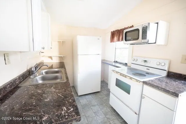 a kitchen with granite countertop a sink and a stove top oven