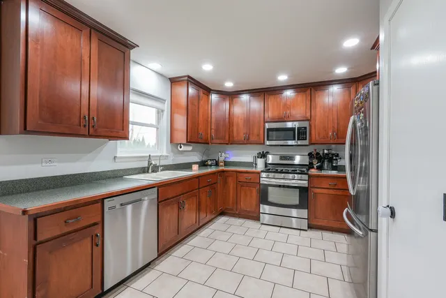 a kitchen with stainless steel appliances granite countertop a refrigerator and a stove top oven