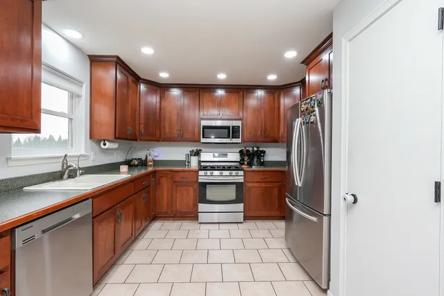 a kitchen with stainless steel appliances granite countertop a refrigerator and a sink