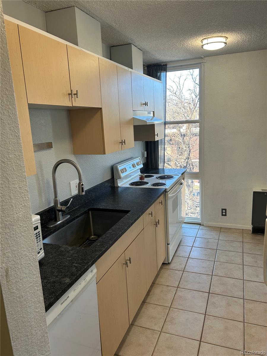 2500 South York Street, Unit 401 Denver, CO 80210 - Photo 5 of 18 a kitchen with granite countertop a sink stove and cabinets