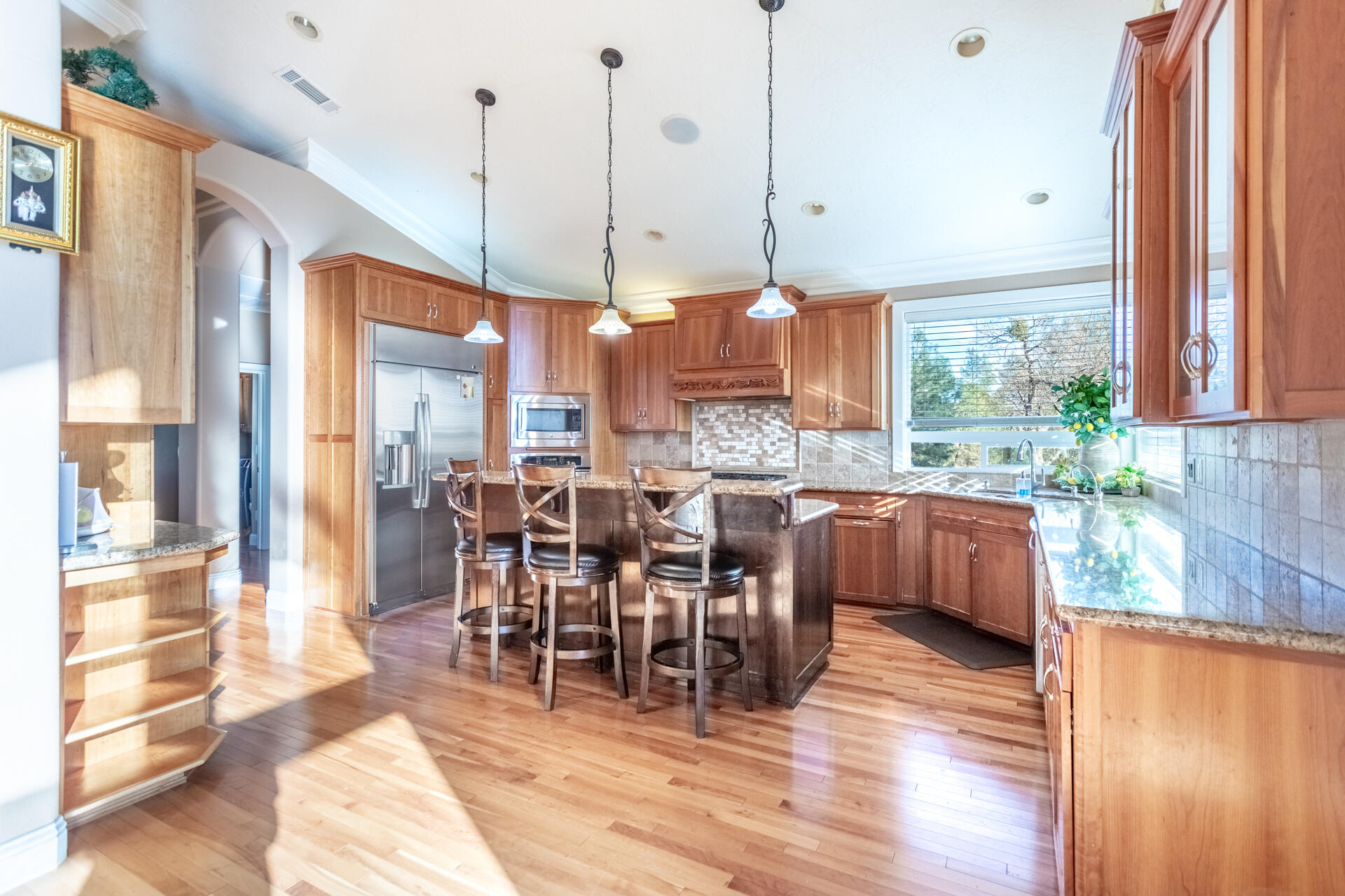 7775 Muletown Road Redding, CA 96001 - Photo 7 of 46 a open kitchen with stainless steel appliances granite countertop a stove top oven a sink a dining table and chairs with wooden floor