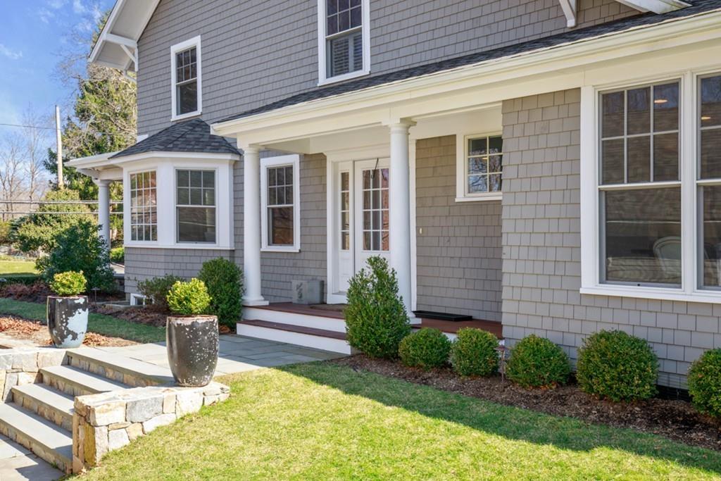 73 Winter Street Hingham, MA 02043 - Photo 2 of 42 a view of a brick house with plants and many windows