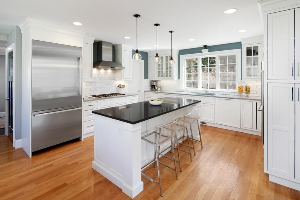73 Winter Street Hingham, MA 02043 - Photo 3 of 42 a kitchen with stainless steel appliances granite countertop a refrigerator a sink a stove and white cabinets with wooden floor