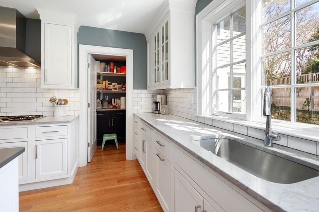 73 Winter Street Hingham, MA 02043 - Photo 4 of 42 a kitchen with granite countertop a sink and white cabinets