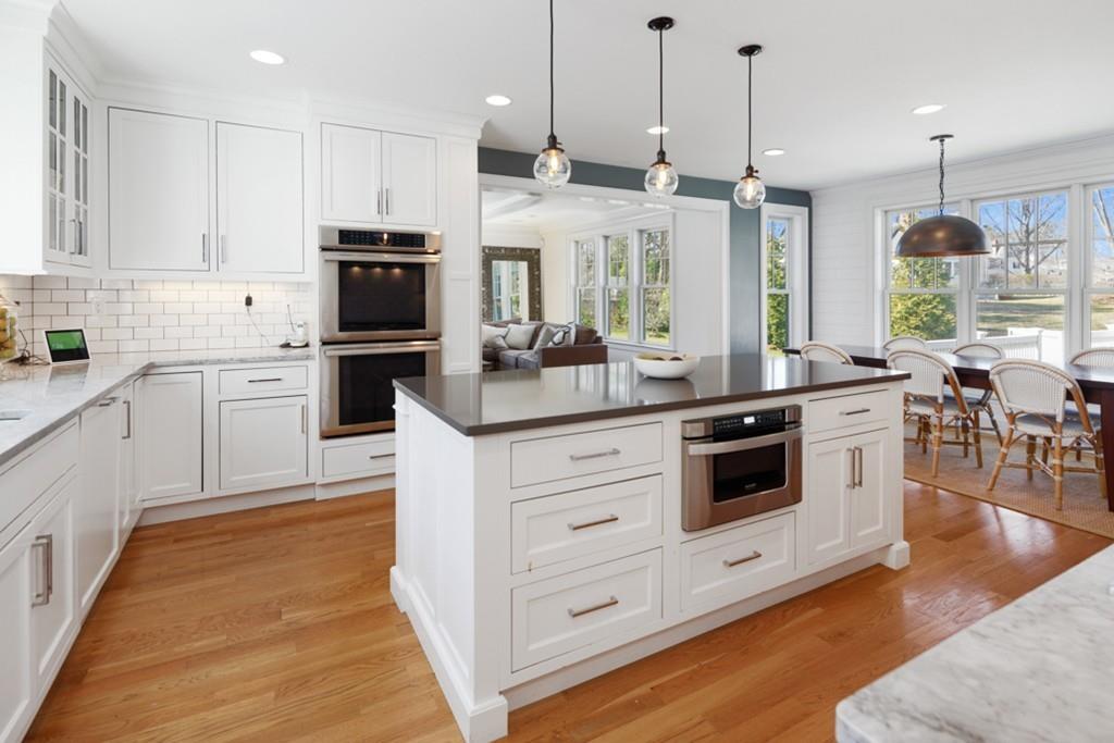 73 Winter Street Hingham, MA 02043 - Photo 5 of 42 a kitchen with stainless steel appliances granite countertop a stove a sink and white cabinets with wooden floors