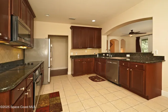 a kitchen with stainless steel appliances granite countertop a stove a sink and a refrigerator