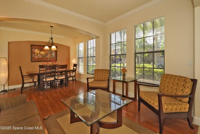 a living room with furniture and floor to ceiling windows