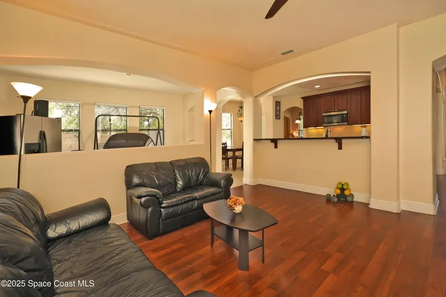 a living room with furniture and a wooden floor