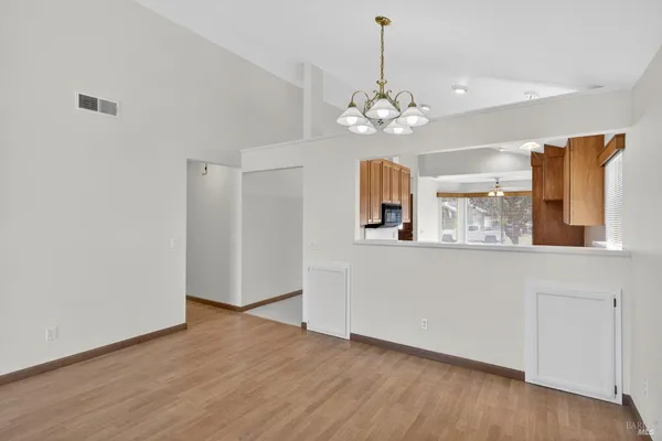 a view of a kitchen with a wooden floor and a ceiling fan