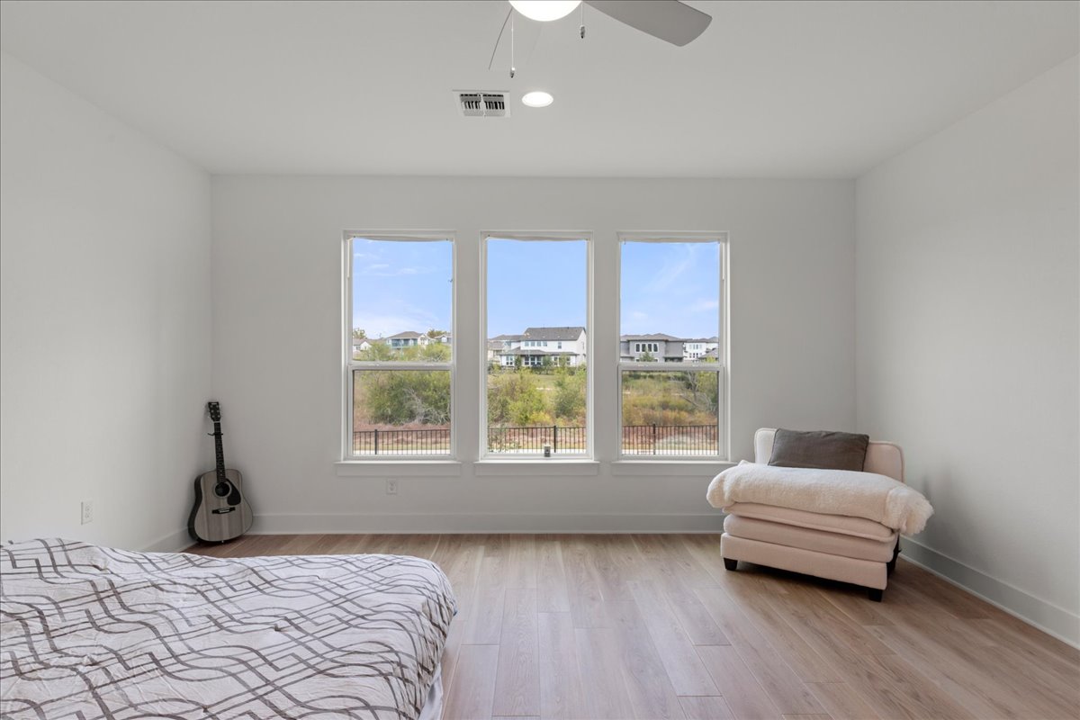 8700 Olmsted Way Austin, TX 78744 - Photo 21 of 40 Bedroom with light wood-style flooring, multiple windows, a ceiling fan, and recessed lighting