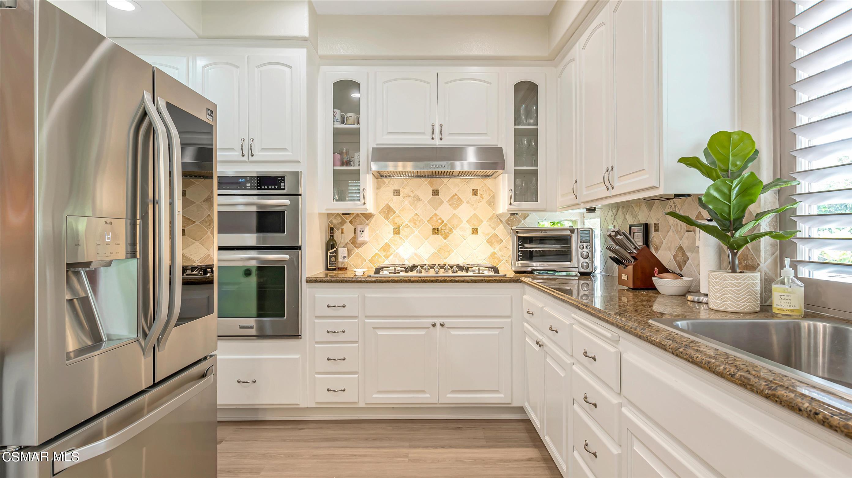 11695 Sagewood Drive Moorpark, CA 93021 - Photo 13 of 31 a kitchen with stainless steel appliances white cabinets and a granite counter tops