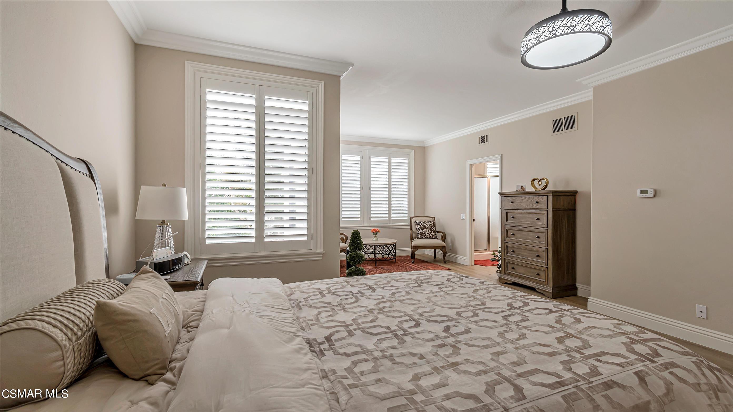 11695 Sagewood Drive Moorpark, CA 93021 - Photo 21 of 31 a bedroom with a bed next to a window and a chandelier