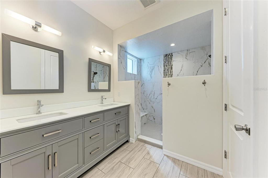 51 Webb Street Osprey, FL 34229 - Photo 28 of 56 a spacious bathroom with a double vanity sink a mirror and a shower