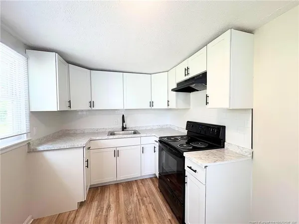 a kitchen with stainless steel appliances a sink stove and white cabinets