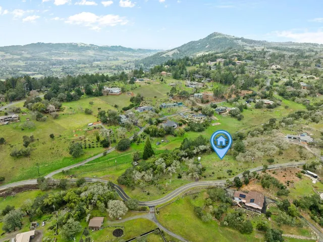 a view of dirt field with trees around