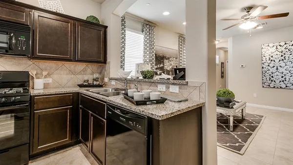 a kitchen with stainless steel appliances granite countertop a sink stove and cabinets