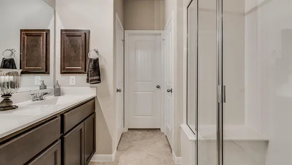 a en suite bathroom with a granite countertop sink and a mirror