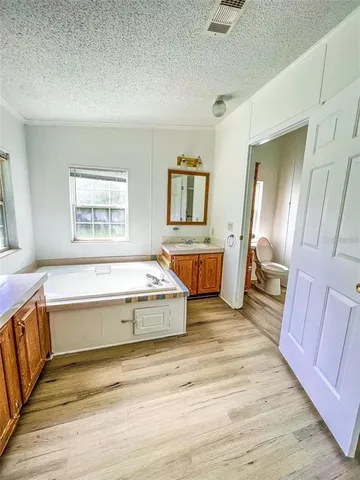 a spacious bedroom with a bed and wooden floor