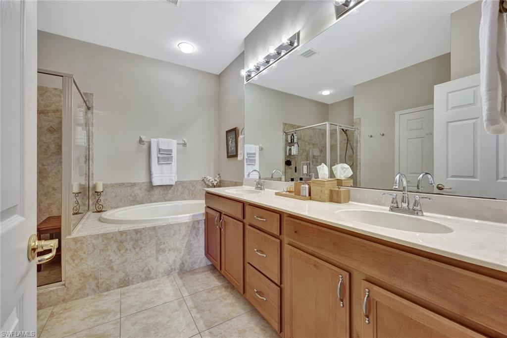 9110 Spanish Moss Way, Unit 422 Bonita Springs, FL 34135 - Photo 14 of 20 a spacious bathroom with a bathtub shower sink double vanity and mirror