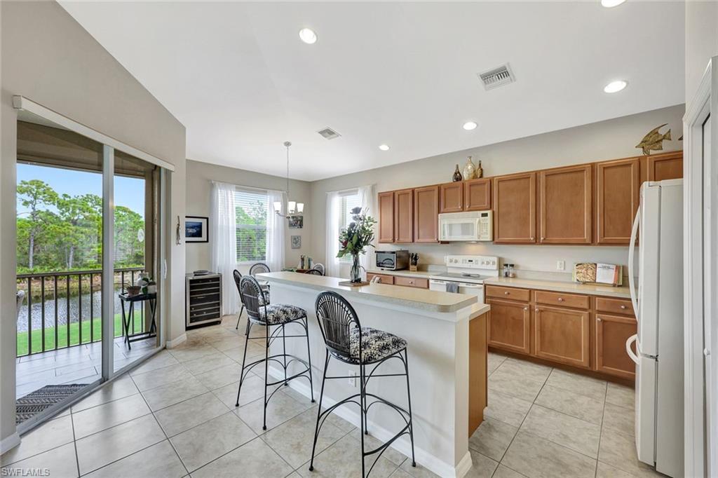 9110 Spanish Moss Way, Unit 422 Bonita Springs, FL 34135 - Photo 6 of 20 a kitchen with stainless steel appliances granite countertop a refrigerator and a stove top oven