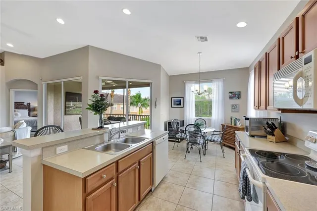 a kitchen with a sink stove and chairs