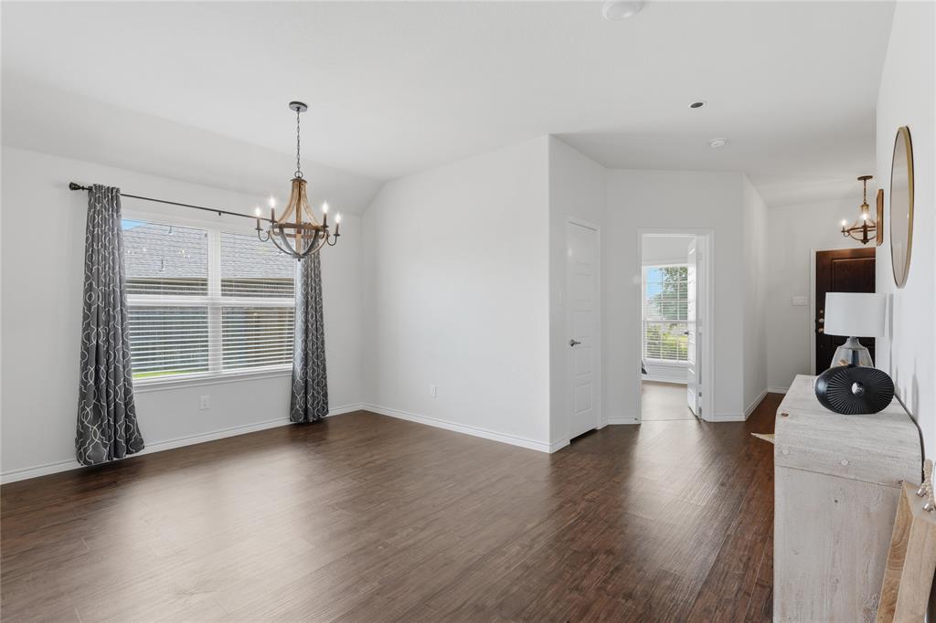 10101 Travis Road Little Elm, TX 75068 - Photo 7 of 26 a view of an empty room with a window and wooden floor