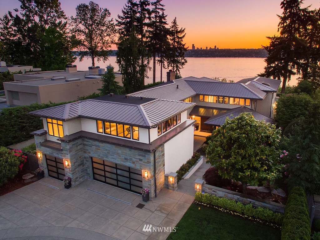 a view of a white house with large trees and a small yard
