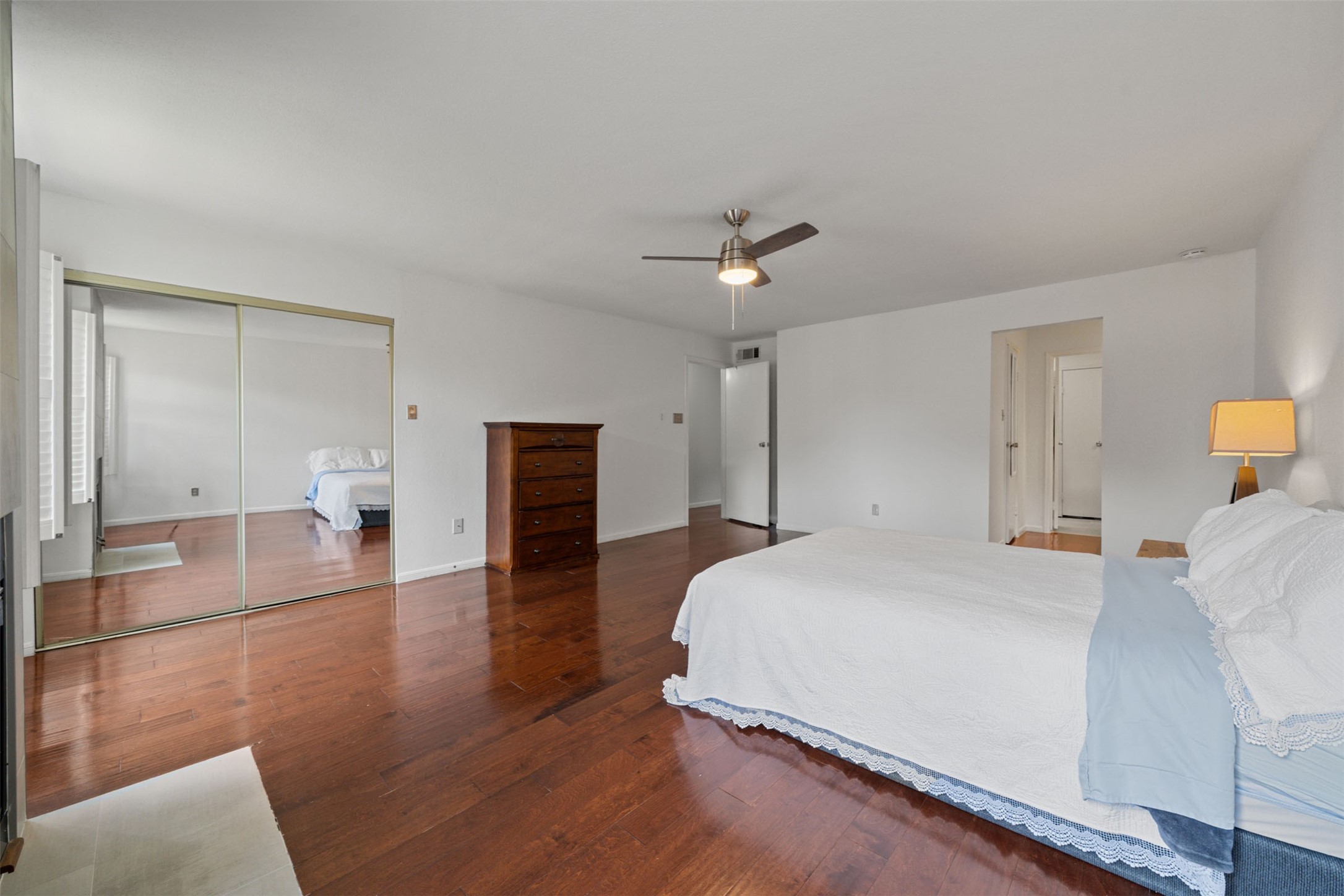 9850 Pagewood Lane, Unit 1402 Houston, TX 77063 - Photo 14 of 35 a spacious bedroom with a bed and a chandelier