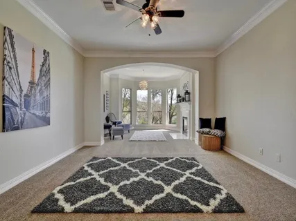 a living room with a rug and a chandelier
