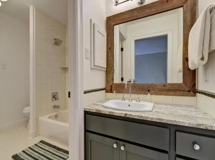 a bathroom with a granite countertop sink and a mirror