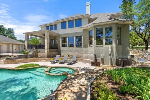 a front view of a house with swimming pool garden and patio