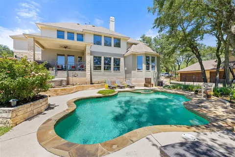 a view of a house with a swimming pool and sitting area