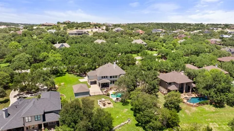 an aerial view of a houses with a yard and lake view