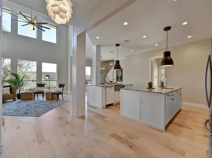 a kitchen with counter top space appliances and living room view