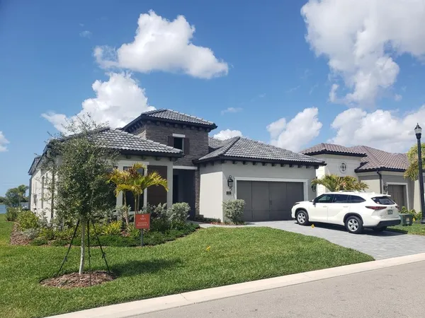 a view of a car parked in front of a house with a fountain