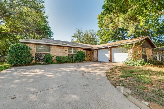 a view of a house with backyard and trees