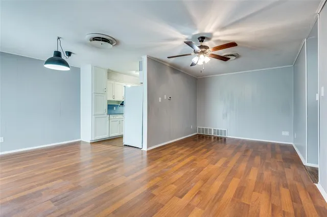 wooden floor in an empty room with a fan
